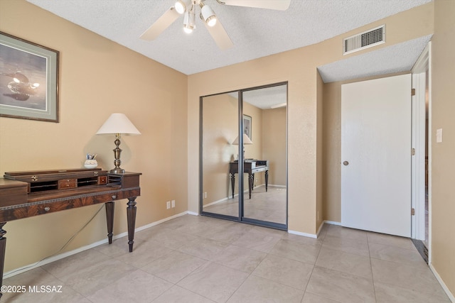 office area with light tile patterned floors, a textured ceiling, and ceiling fan