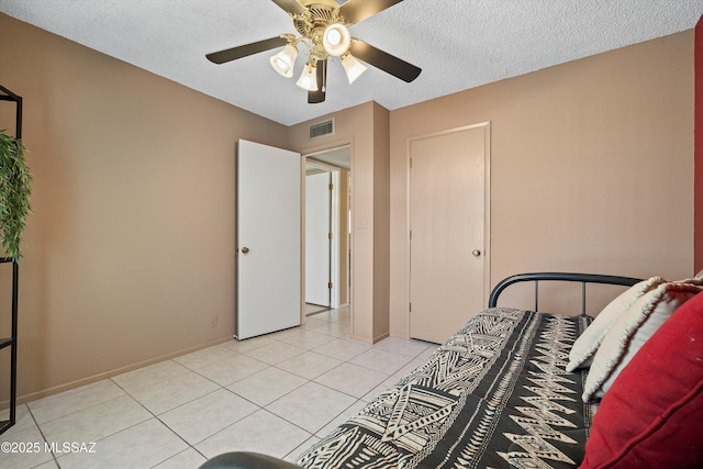 bedroom with light tile patterned flooring, ceiling fan, and a textured ceiling