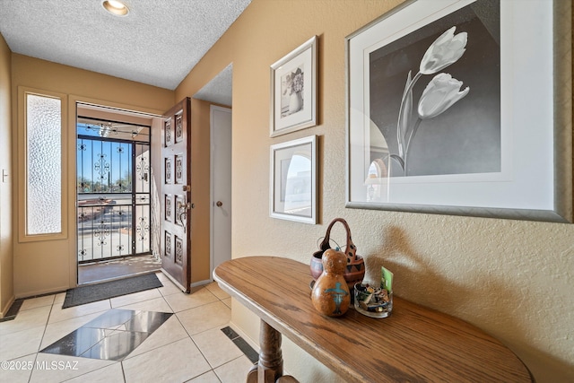 foyer entrance featuring a textured ceiling and light tile patterned floors