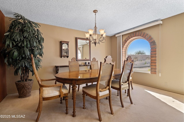 carpeted dining area featuring an inviting chandelier and a textured ceiling