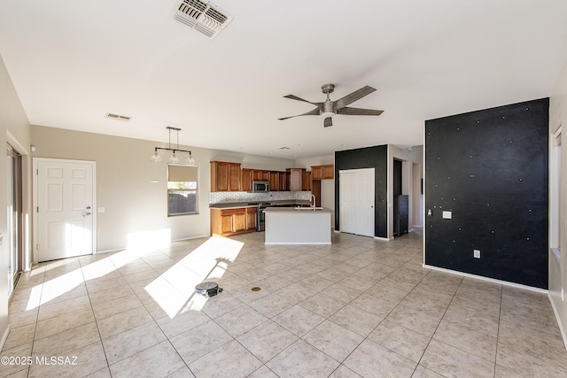 kitchen featuring appliances with stainless steel finishes, sink, backsplash, hanging light fixtures, and ceiling fan