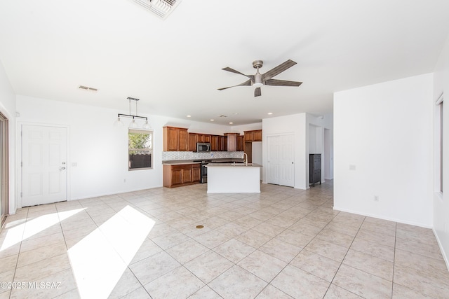 kitchen with a ceiling fan, visible vents, stainless steel appliances, decorative backsplash, and open floor plan