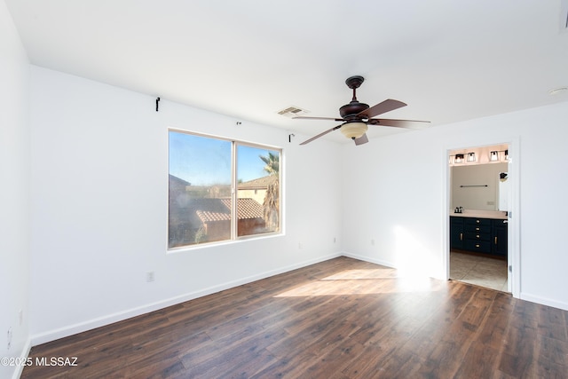 unfurnished bedroom with visible vents, baseboards, wood finished floors, ensuite bath, and a ceiling fan