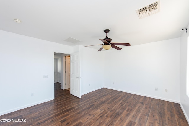 spare room featuring dark wood-style floors, visible vents, ceiling fan, and baseboards