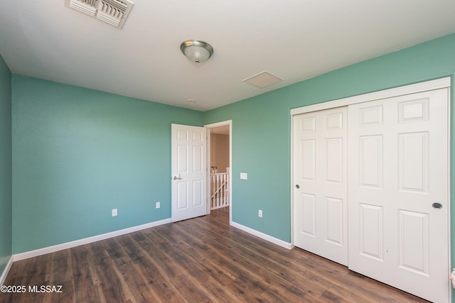 unfurnished bedroom featuring dark wood-type flooring and a closet