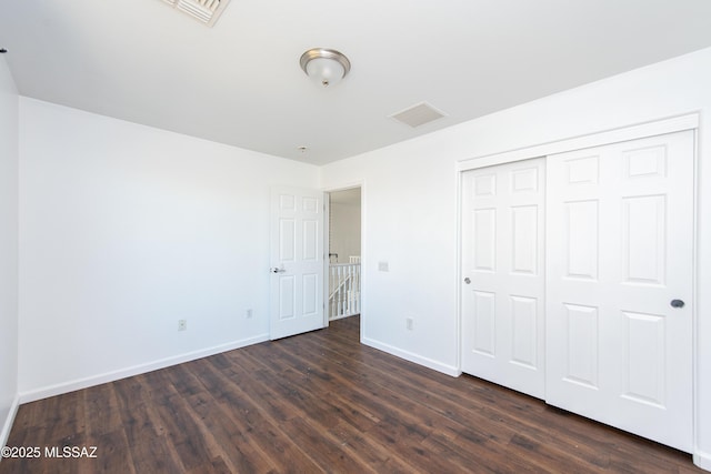 unfurnished bedroom with visible vents, baseboards, and dark wood finished floors