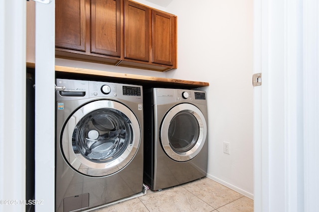 laundry room with light tile patterned floors, baseboards, cabinet space, and independent washer and dryer