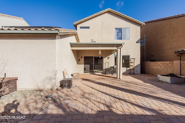 back of house with stucco siding, a patio, central AC, fence, and a tiled roof