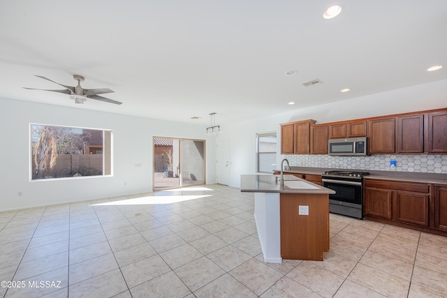 kitchen with stainless steel appliances, visible vents, open floor plan, and decorative backsplash