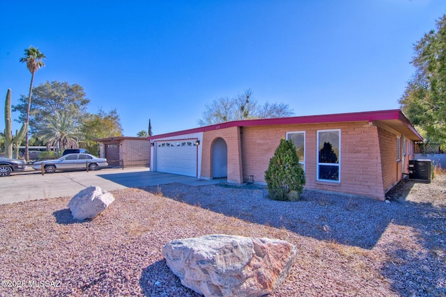 ranch-style house with a garage and central air condition unit