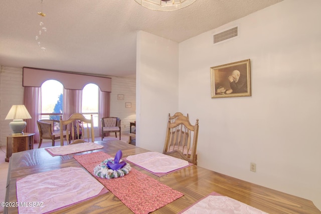 dining room featuring a textured ceiling and light hardwood / wood-style floors