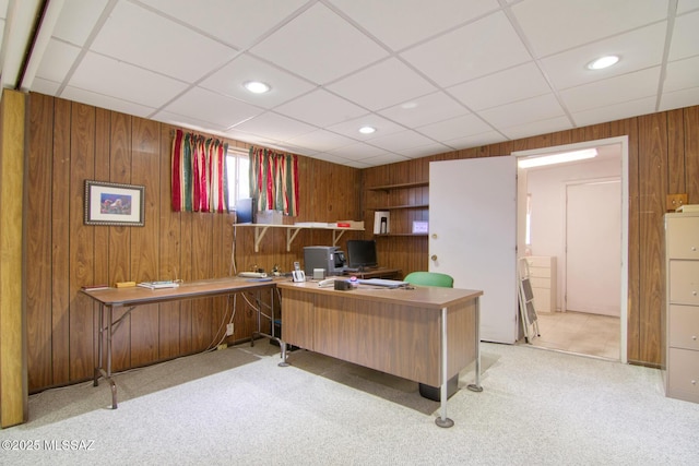 office area featuring wood walls and light carpet