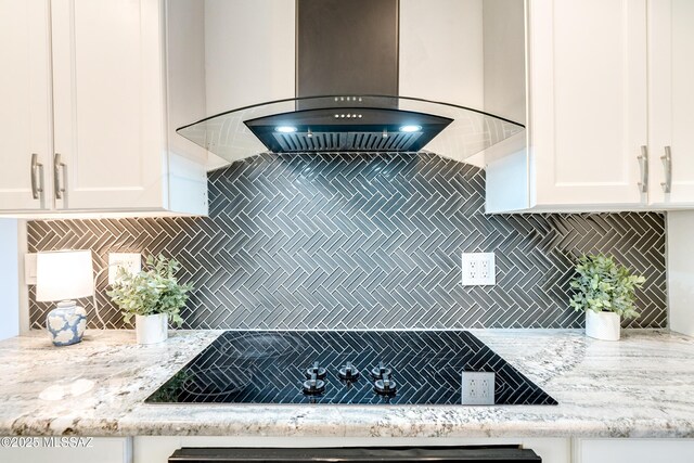 kitchen featuring white cabinetry, a center island with sink, and wall chimney exhaust hood