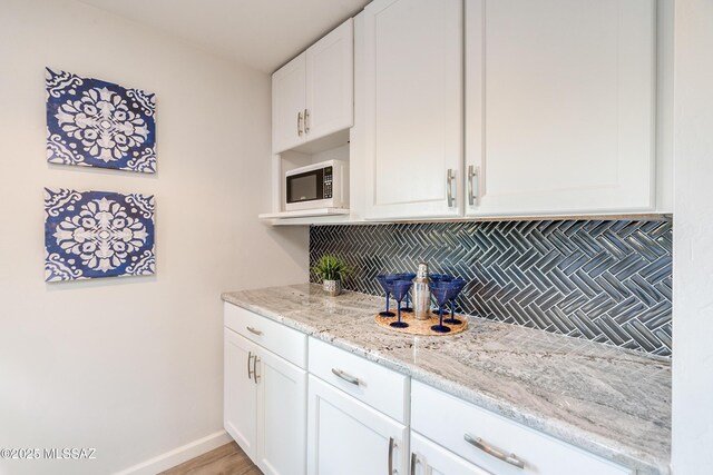 kitchen with white cabinetry, hanging light fixtures, and sink