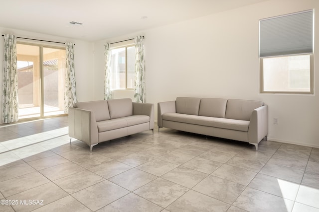 living room with a wealth of natural light and light tile patterned floors