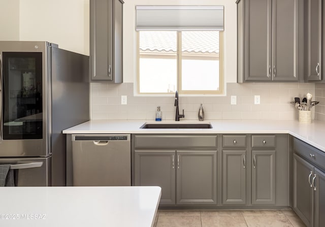 kitchen with gray cabinetry, sink, and appliances with stainless steel finishes