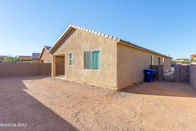 8757 E Pebble Stone Ln, Tucson, AZ 85730 - back of house featuring a fenced backyard, a gate, and stucco siding