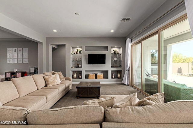 carpeted living room with built in features