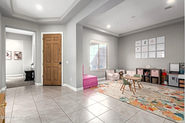 tiled entrance foyer featuring a raised ceiling