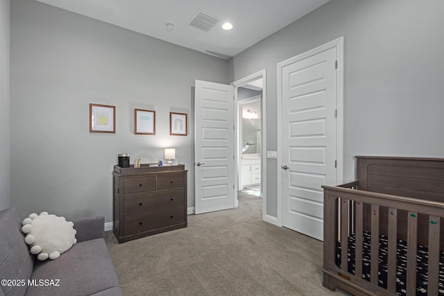 carpeted bedroom featuring a nursery area