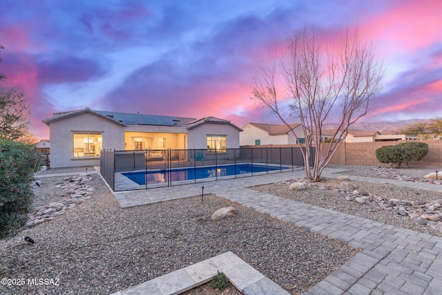 pool at dusk with a patio area