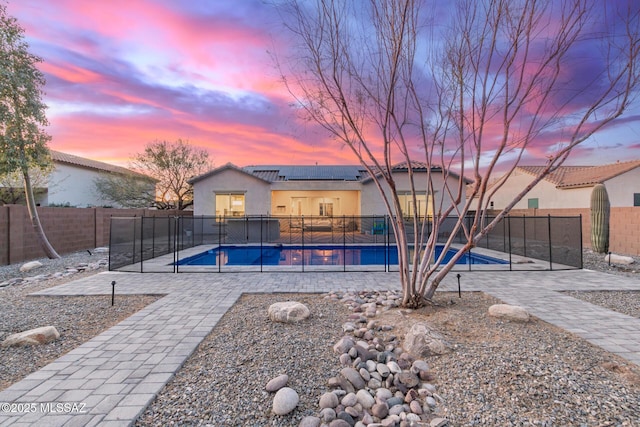 pool at dusk featuring a patio