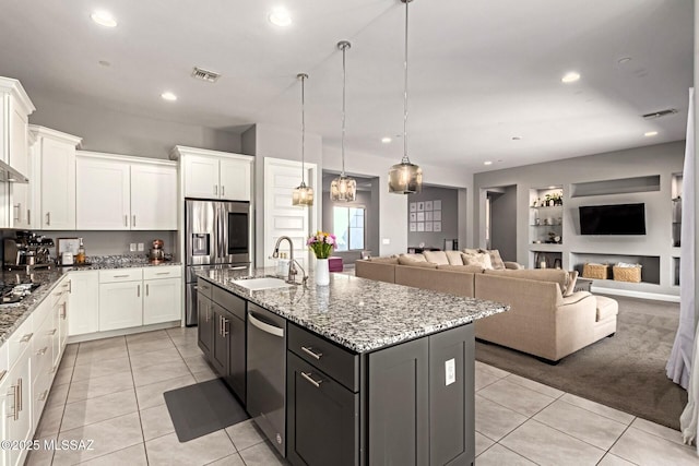 kitchen featuring white cabinetry, pendant lighting, sink, and a center island with sink