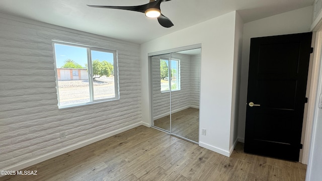 unfurnished bedroom featuring a closet, ceiling fan, and light wood-type flooring