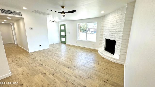 unfurnished living room featuring a fireplace, ceiling fan, and light hardwood / wood-style flooring