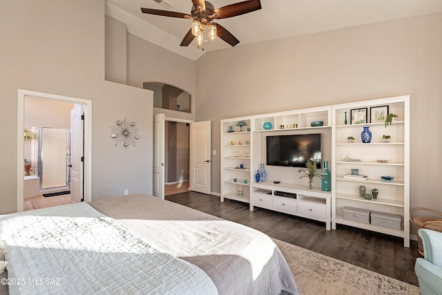 bedroom with dark wood-type flooring, ceiling fan, ensuite bathroom, and high vaulted ceiling