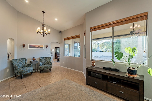 living area with light tile patterned flooring, ceiling fan with notable chandelier, and high vaulted ceiling