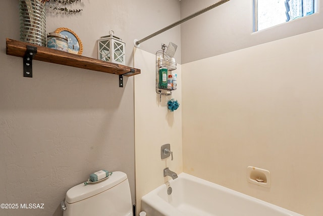 bathroom with tub / shower combination and toilet