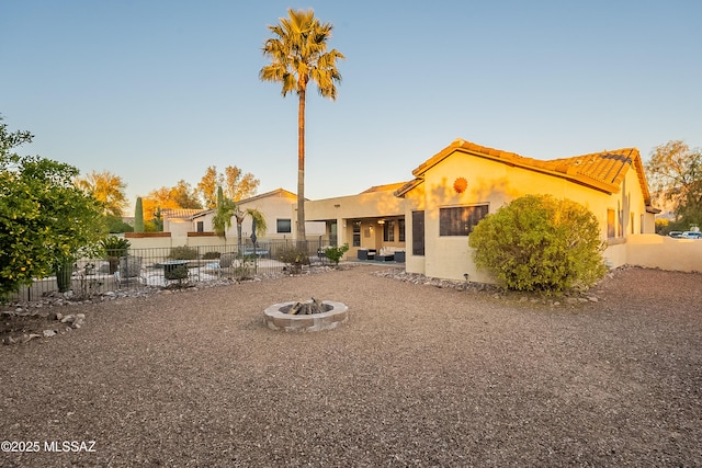 rear view of house featuring a patio and an outdoor fire pit