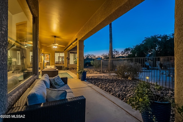 patio terrace at dusk with an outdoor hangout area and ceiling fan