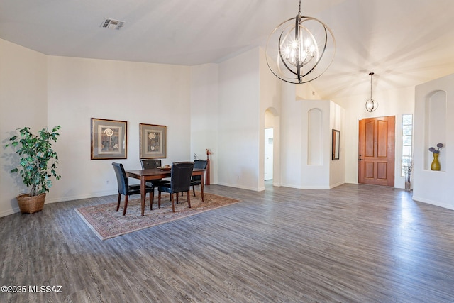 dining space with dark hardwood / wood-style flooring and a chandelier