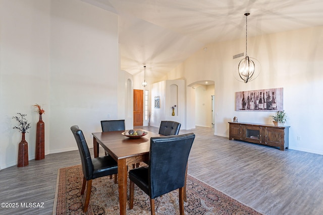 dining space featuring vaulted ceiling, a chandelier, and hardwood / wood-style floors