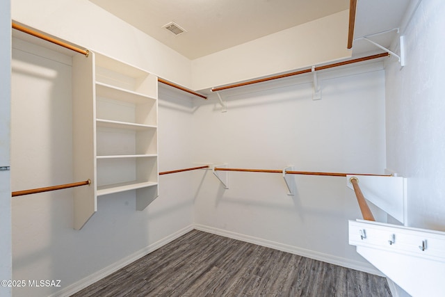 walk in closet with dark hardwood / wood-style flooring