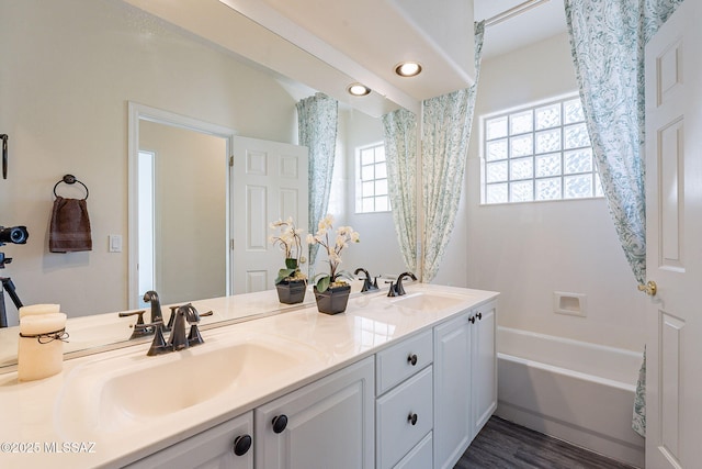 bathroom featuring wood-type flooring, vanity, and a bathing tub