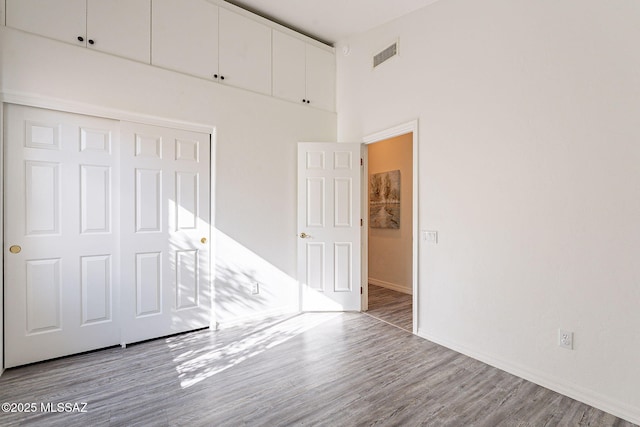 unfurnished bedroom featuring light wood-type flooring and a closet