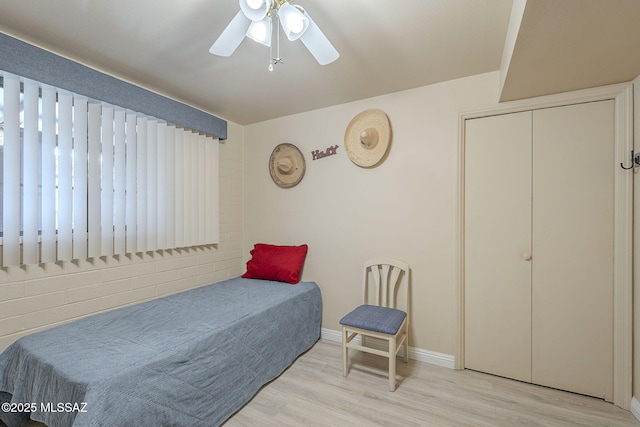 bedroom featuring baseboards, wood finished floors, and ceiling fan