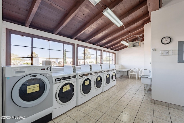 community laundry room featuring light tile patterned floors, wooden ceiling, washing machine and clothes dryer, and electric panel