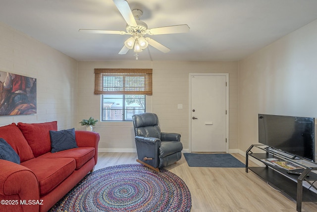 living area featuring baseboards, ceiling fan, and light wood-style floors