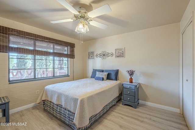 bedroom with ceiling fan, baseboards, and light wood-style floors