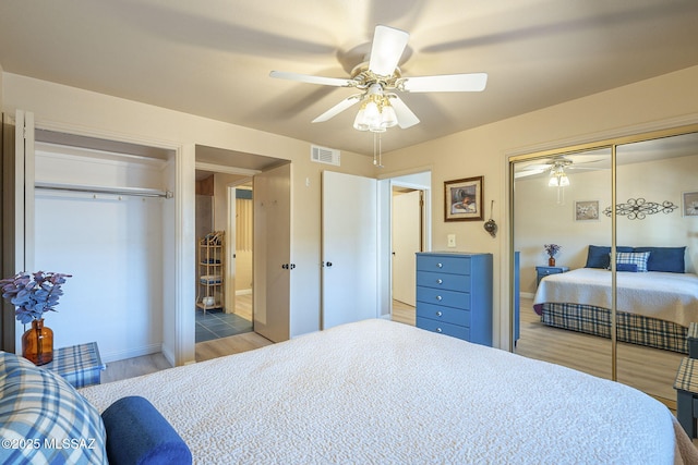 bedroom featuring wood finished floors, visible vents, ceiling fan, and baseboards