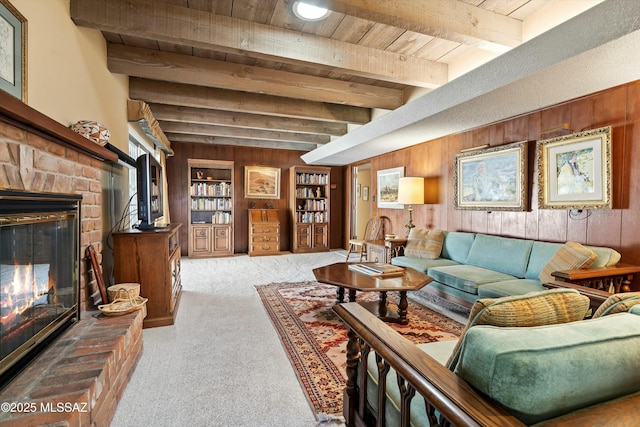 carpeted living room featuring a brick fireplace, built in features, wooden walls, and beam ceiling