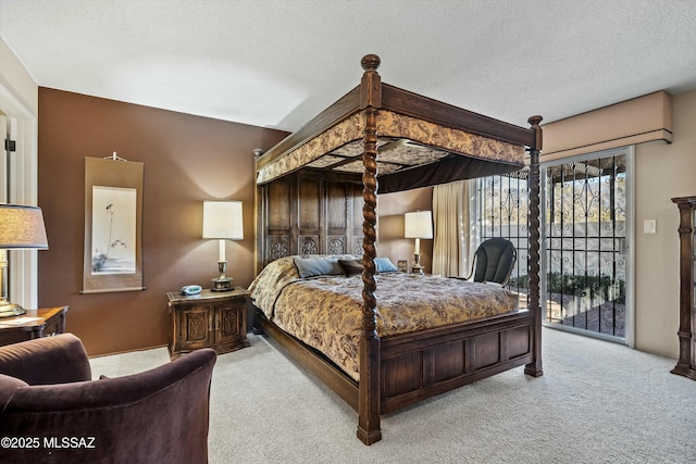 bedroom with a textured ceiling, access to exterior, and light carpet