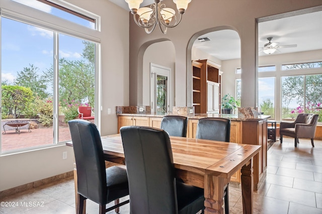 dining room with ceiling fan with notable chandelier and light tile patterned floors