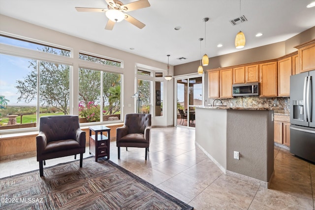 kitchen featuring backsplash, hanging light fixtures, a healthy amount of sunlight, stainless steel appliances, and light stone counters