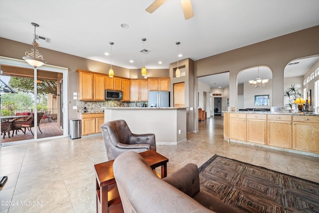 living room featuring ceiling fan with notable chandelier