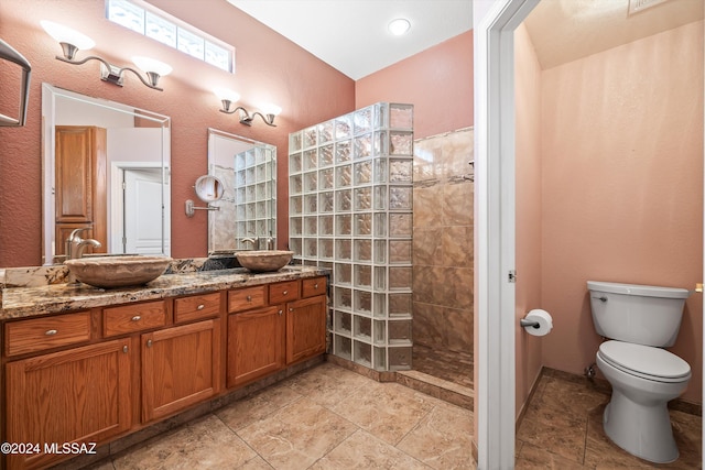 bathroom featuring toilet, vanity, and a tile shower